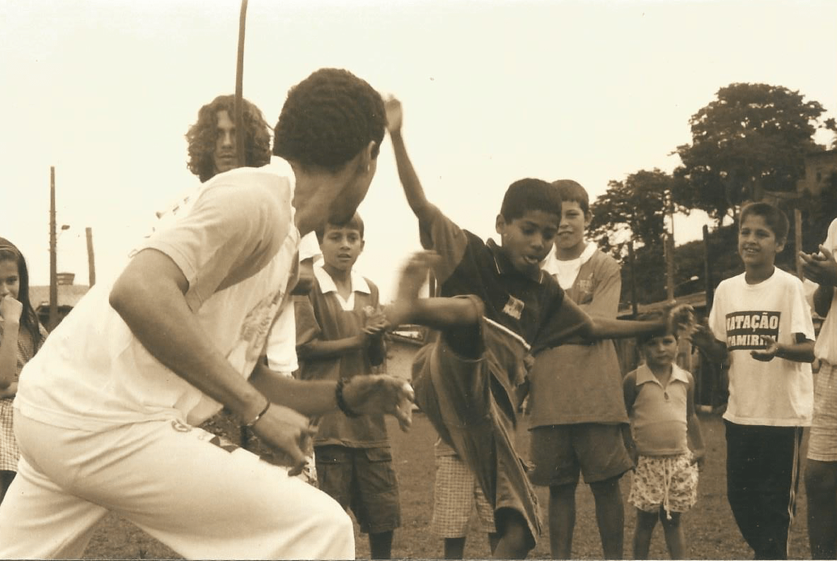 Ricardo Casarini (berimbau) e Osíris Duarte (jogando capoeira) durante uma das festas promovidas no dia das crianças